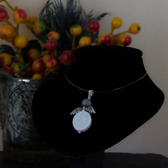 Engel aus Perlmutt mit Silberflügeln und satinierter Perle auf schwarzer Büste 